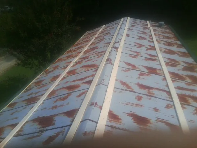 Rusted metal roof panels with new wood purlins before replacement — Storm Damage Roof Repair in Stephentown by Roofing Brothers