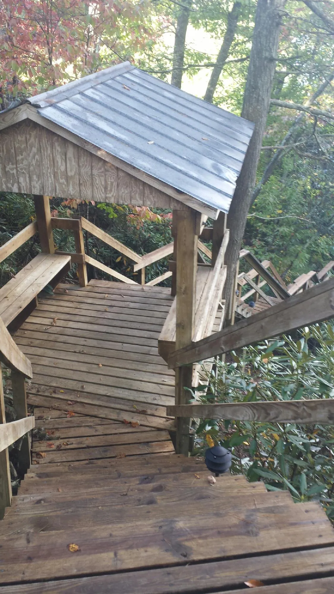 Metal roofed shelter over wooden steps on a wooded walkway — Skylight Repair & Installation work by our crew in Stephentown