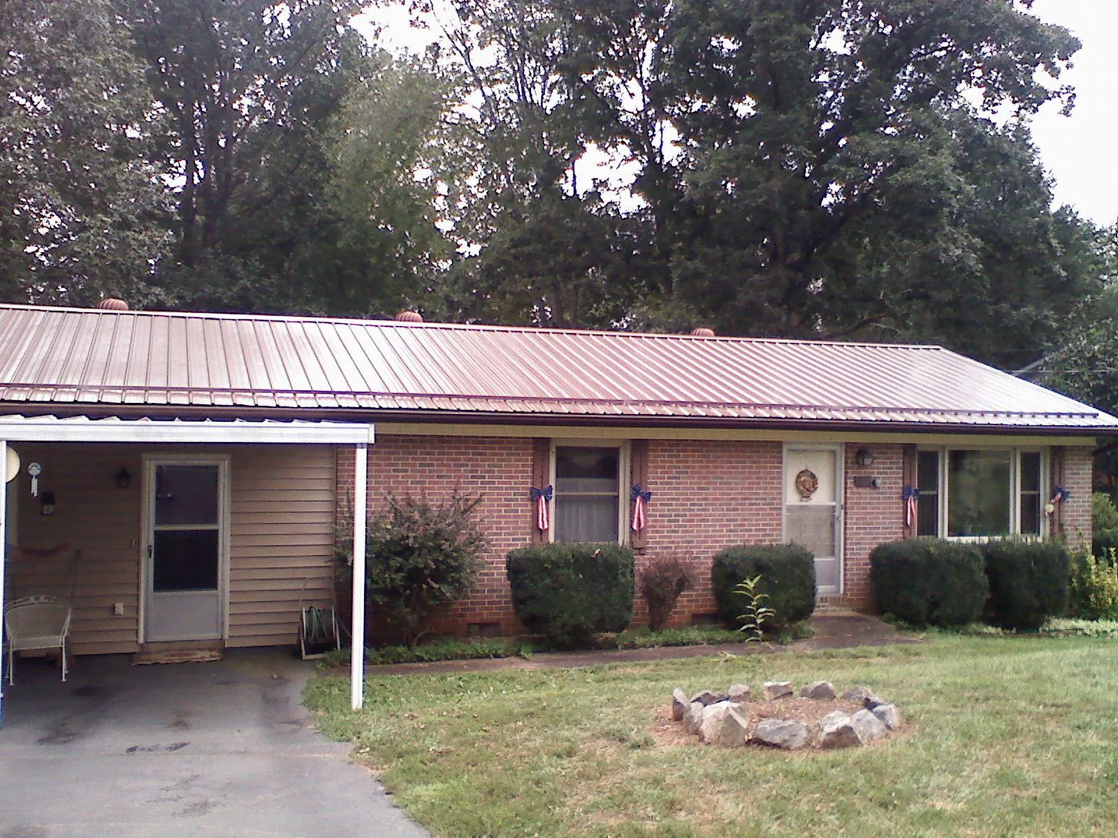 Bronze metal roof and carport on a brick ranch home — Roof Repair work by our crew in Stephentown